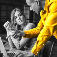 Man explaining an issue to a woman at a laptop