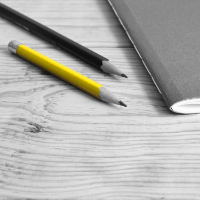 Two pencils and a notebook on a table