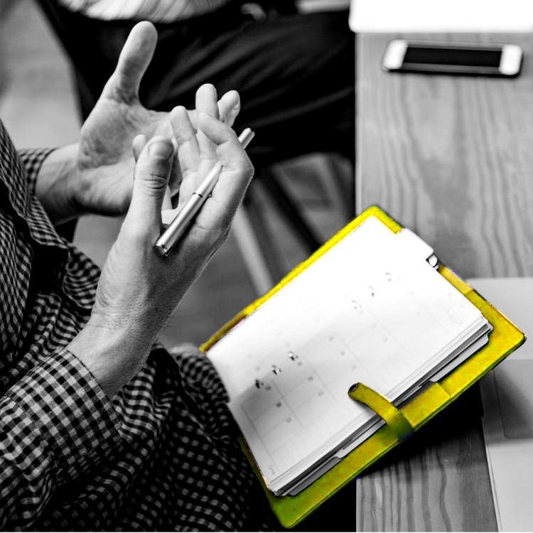 Man Gesturing Above Binder